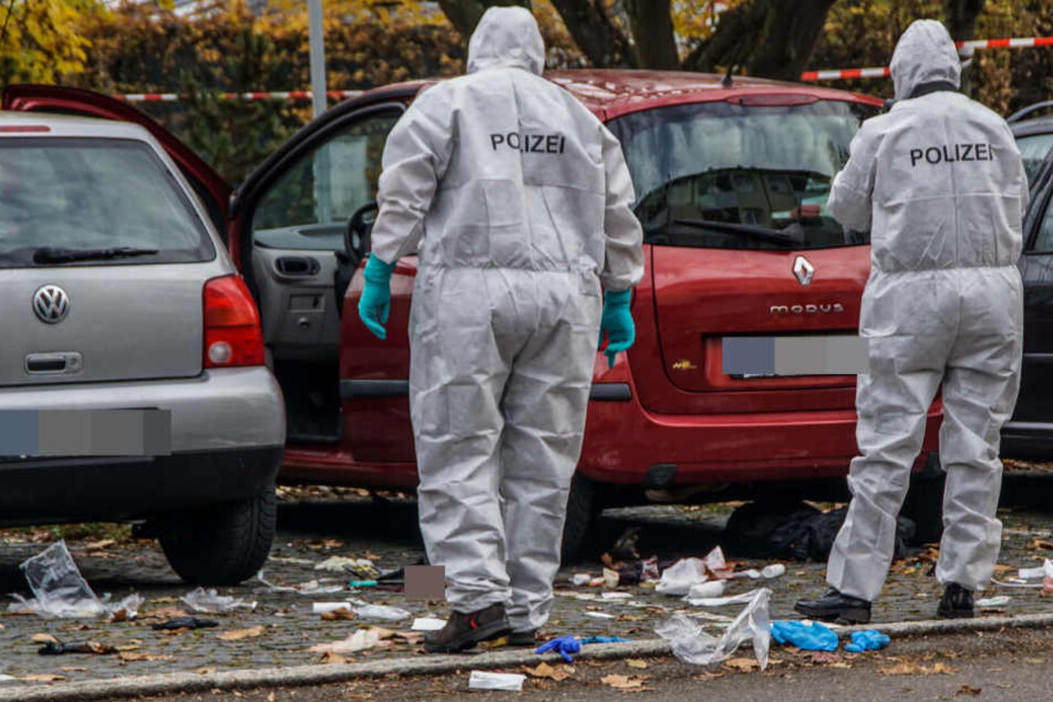 Ermittler vor dem Wagen des Opfers.