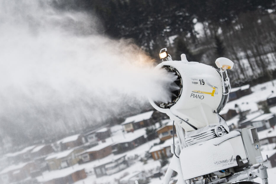 Eine Schneekanone steht im Skigebiet in Winterberg und beschneit eine Skipiste.