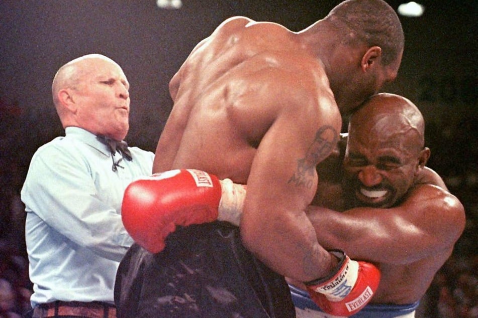 In diesem legendären Moment der Box-Geschichte biss Mike Tyson (M.) seinem Gegner Evander Holyfield (r.) einen Teil seines Ohres ab. (Archivbild)