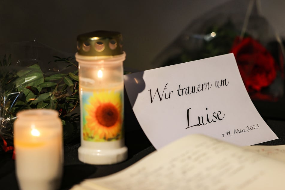 Ein Kondolenzbuch für die getötete 12-jährige Luise liegt neben Blumen und Kerzen in der Evangelischen Kirche in Freudenberg aus.