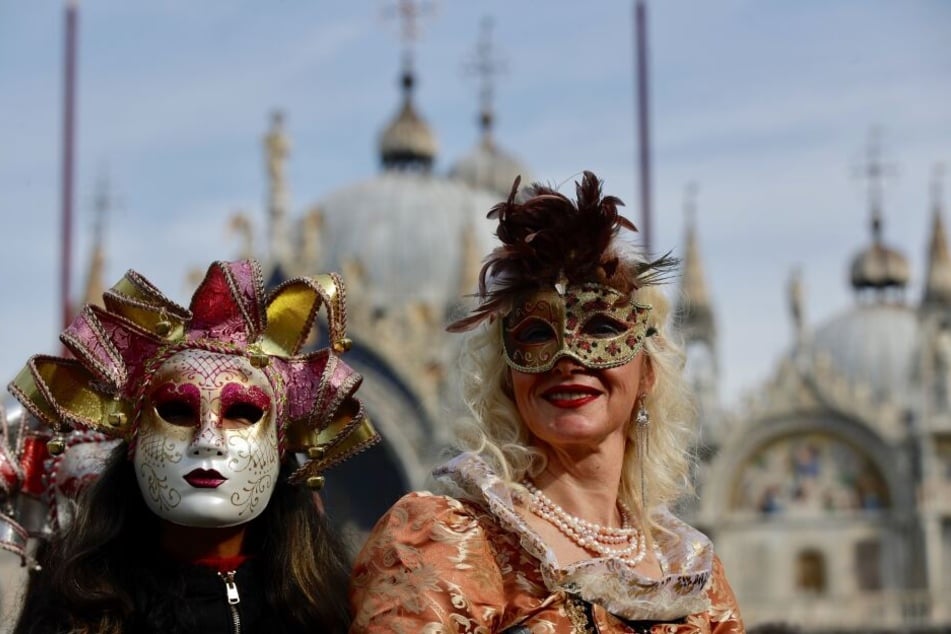 Zwei kostümierte Frauen in Venedig mit den landestypischen Masken.