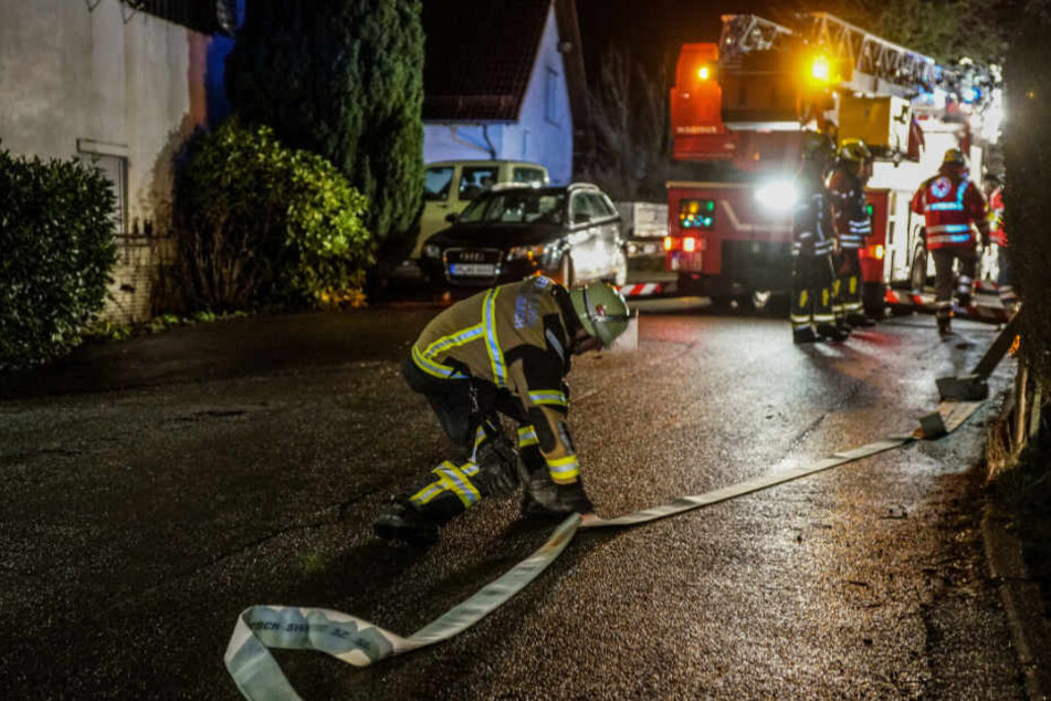 Ein Feuerwehrmann legt einen Löschschlauch zurecht.