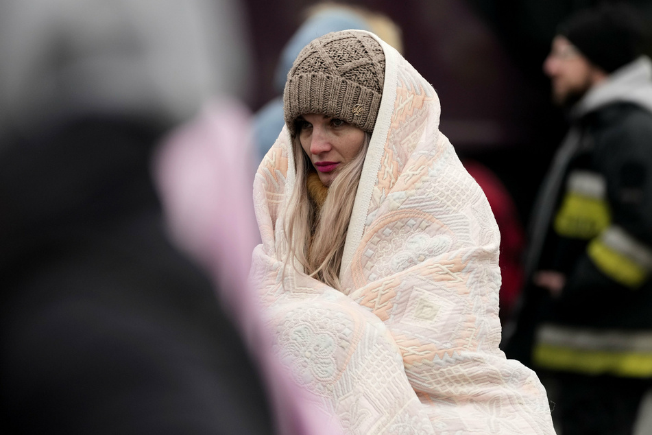 Viele Geflüchtete haben nur das Nötigste mitgenommen. Hier wartet eine Frau, eingewickelt in eine Decke, in Polen auf ihre Weiterreise.