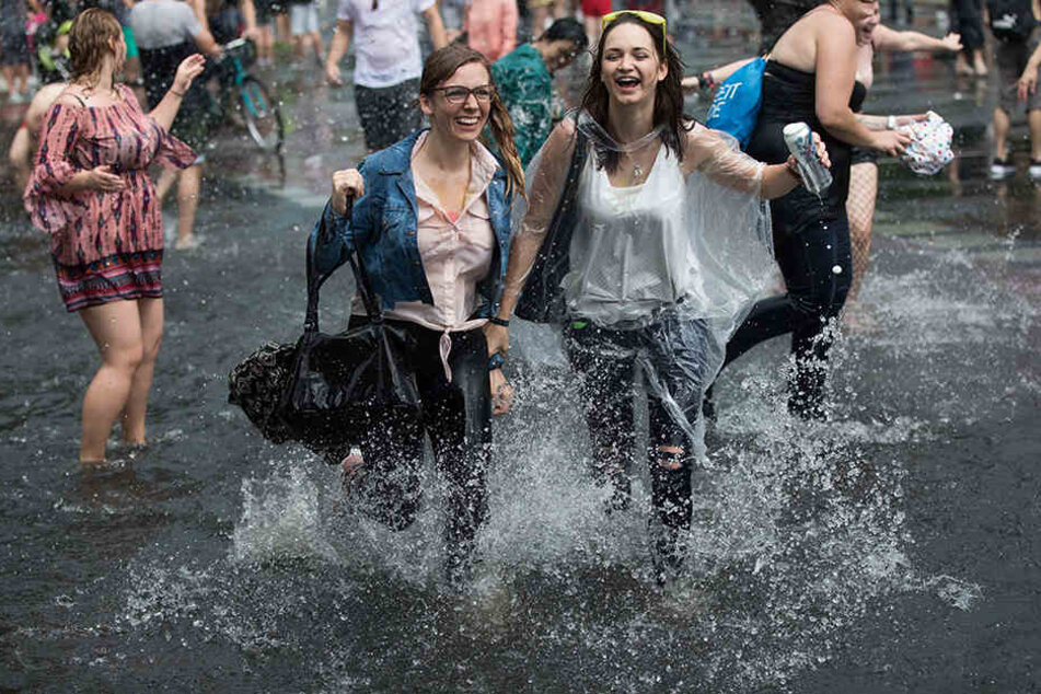 Die Teilnehmer ziehen in Berlin während eines Regenschauers beim Christopher Street Day (CSD) unter dem Motto "Mehr von uns - jede Stimme gegen rechts" für die Rechte von schwulen, lesbischen, bi- und transsexuellen Menschen über die Straße des 17. Juni z