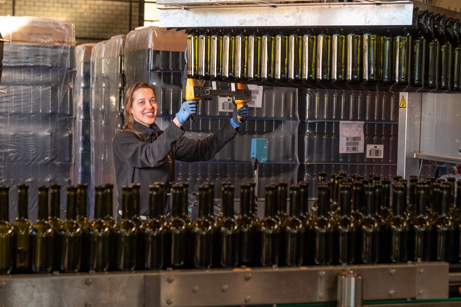 Weinküferin Anna Eichhorn steuert den "Flaschengreifer" mit einem Controller.
