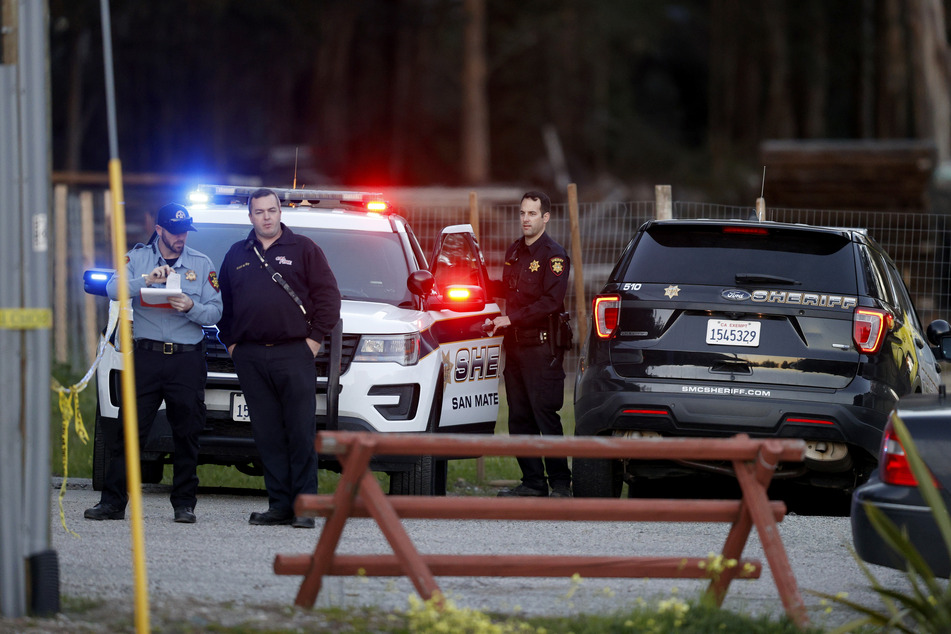 Beamte der San Mateo County Sheriffs und Mitarbeiter des Rettungsdienstes versammeln sich entlang einer Straße in der Nähe des Ortes Half Moon Bay, wo mehrere Menschen erschossen aufgefunden wurden.
