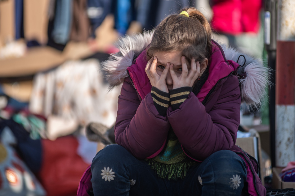 Ein Mädchen, das vor dem Krieg in der Ukraine geflohen ist, sitzt erschöpft im Flüchtlingslager Medika in Polen.