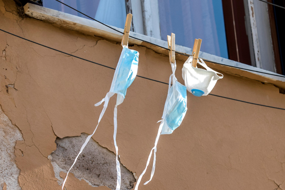 Rom: Mundschutzmasken hängen zum Trocknen an einer Leine vor einem Wohnungsfenster. 