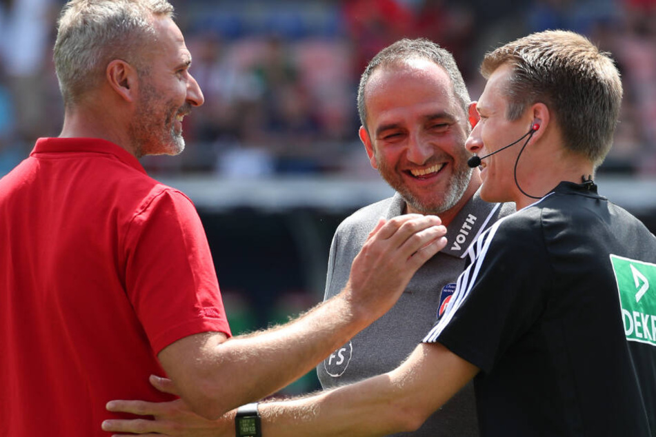 Der Heidenheimer Trainer Frank Schmidt (M) unterhält sich mit dem Stuttgarter Trainer Tim Walter (l) und dem Schiedsrichter Benjamin Cortus vor Spielbeginn.