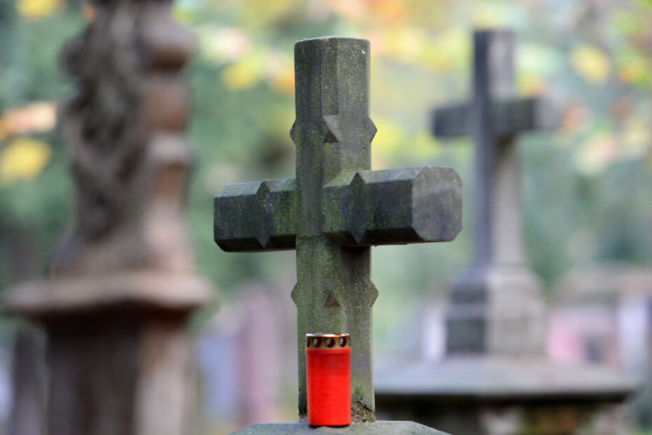 Ein Kreuz steht auf einem Friedhof.