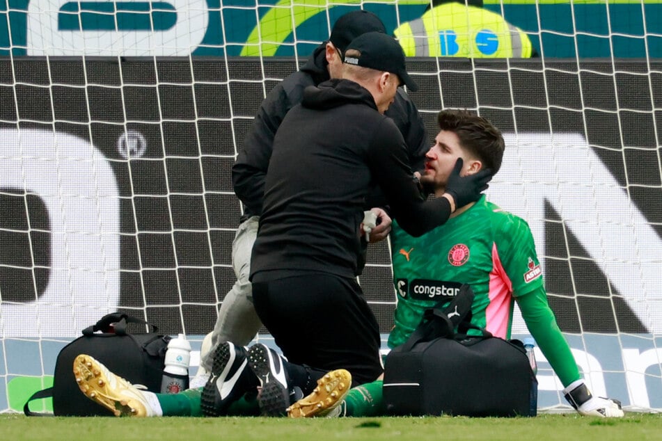 St. Paulis Keeper Nikola Vasilj holte sich bei einer Rettungstat und einem anschließenden Zusammenprall eine blutige Nase.