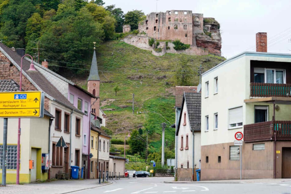 Häuser stehen in der pfälzischen Kommune Frankenstein vor der Burgruine Frankenstein.