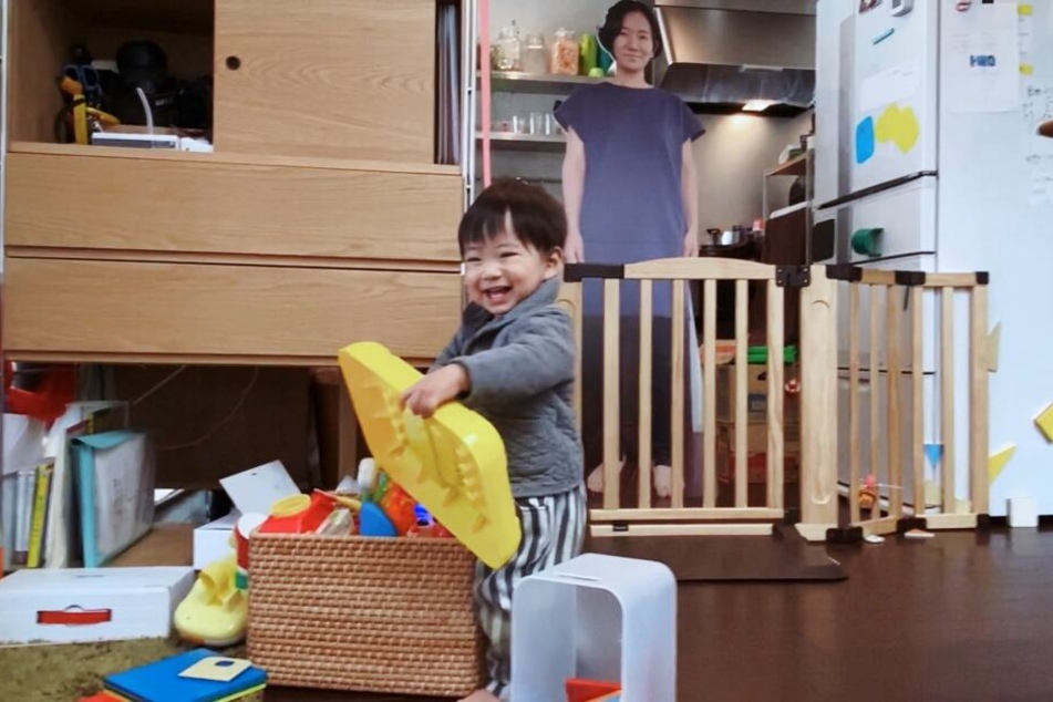 Die Papp-Mama mit ihrem fröhlich spielenden Sohn.
