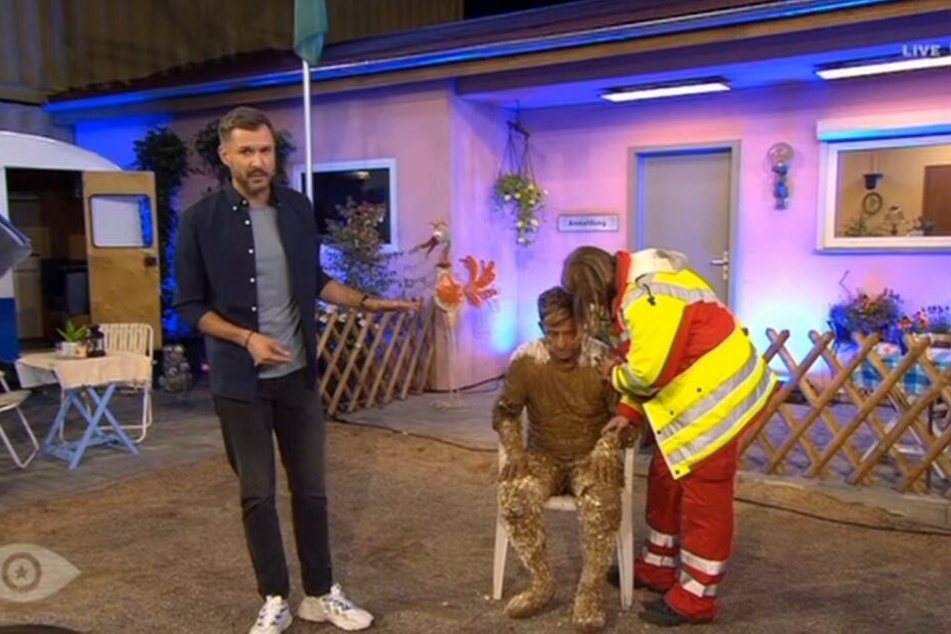 Jochen Schropp moderierte neben dem mit Schlamm getränkten und sichtlich beeinträchtigten Almklausi weiter. Der "Mama Laudaaa"-Sänger wurde danach in eine Klinik gebracht.