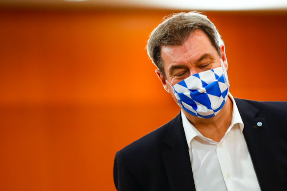 Markus Söder (53, CSU), Ministerpräsident von Bayern, trägt eine Gesichtsmaske mit dem weiß-blauen Rautenmuster Bayerns.