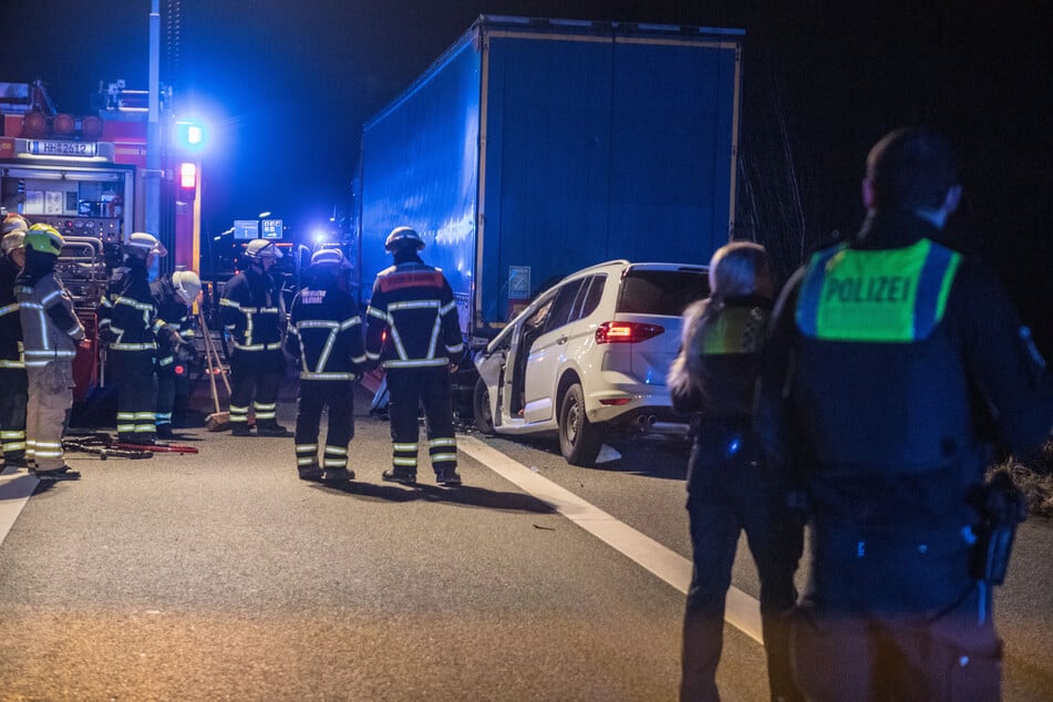 Einsatzkräfte von Polizei und Feuerwehr stehen an der Unfallstelle auf der A1.