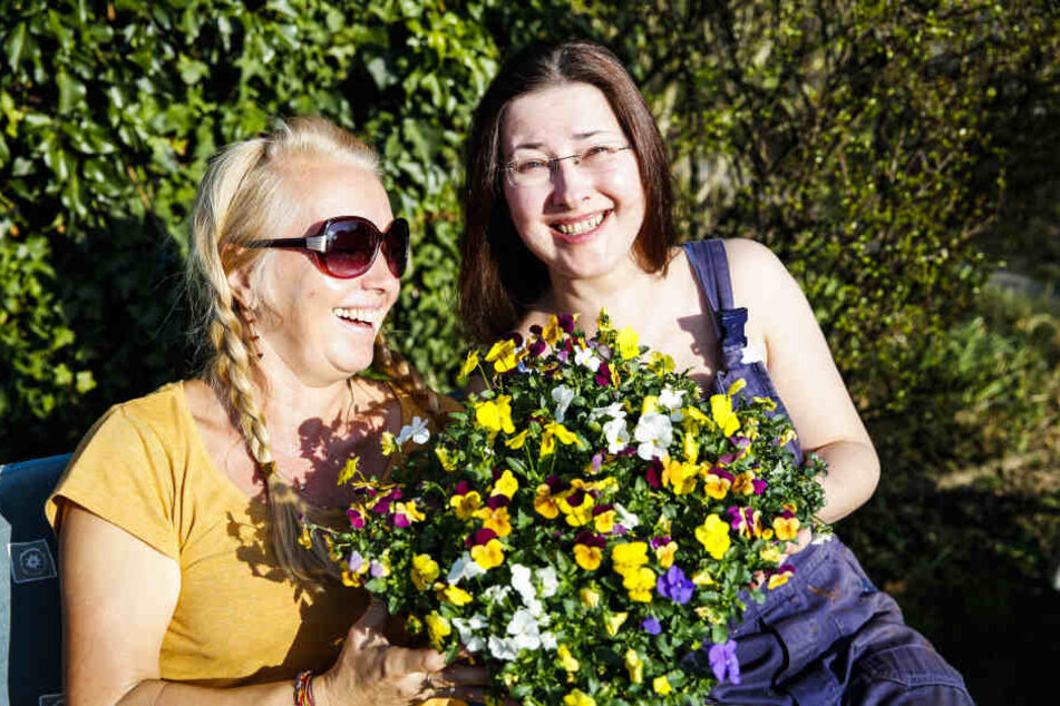 Kerstin (54) und Nele (39) genießen im Garten die Frühlingssonne und erfreuen sich an bunten Horn-Veilchen.