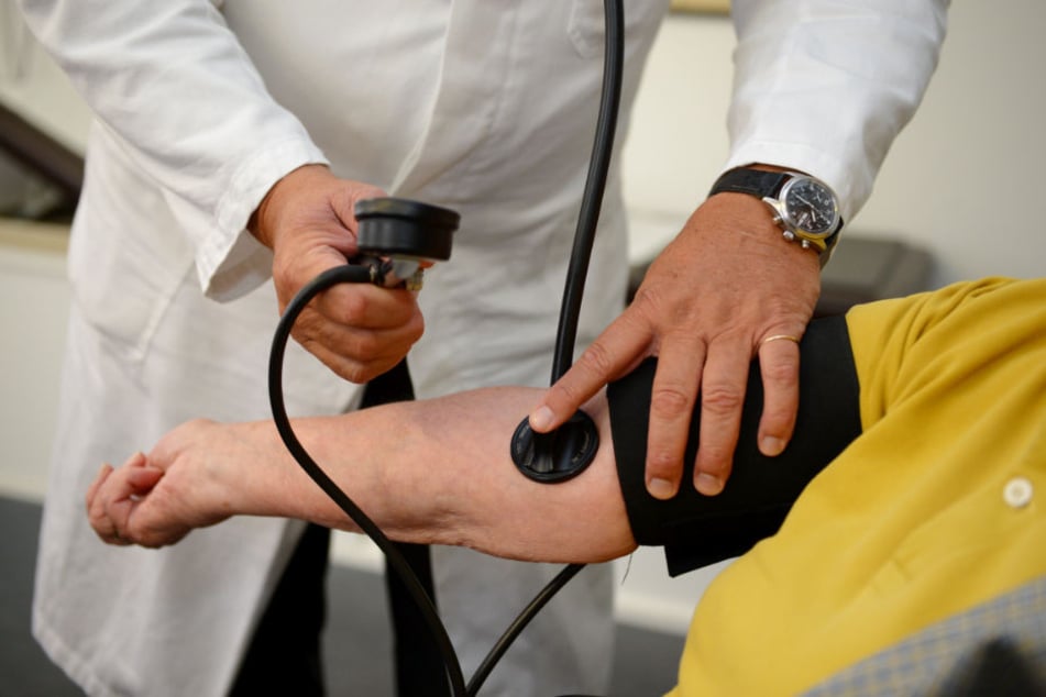 Ein Hausarzt misst in seiner Praxis einer Patientin den Blutdruck. (Symbolbild)