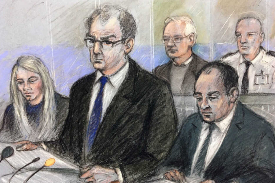 Diese Gerichtszeichnung von Elizabeth Cook zeigt Julian Assange (hinten,li.) während der Anhörung. Staatsanwalt James Lewis (vorne, Mi.) spricht im Belmarsh Magistrates Gericht.