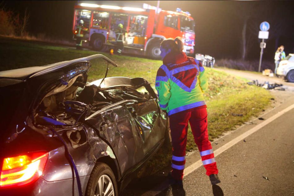 Eine Mitarbeiterin des Rettungsdienstes sieht in eines der Unfallfahrzeuge.