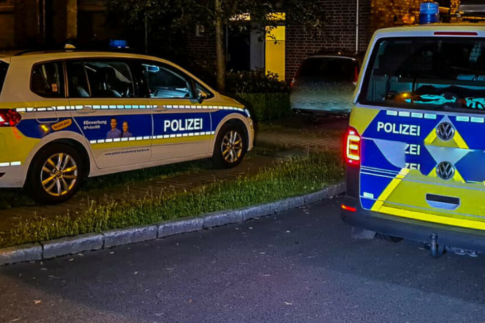 Polizeiwagen stehen an einer Straße.