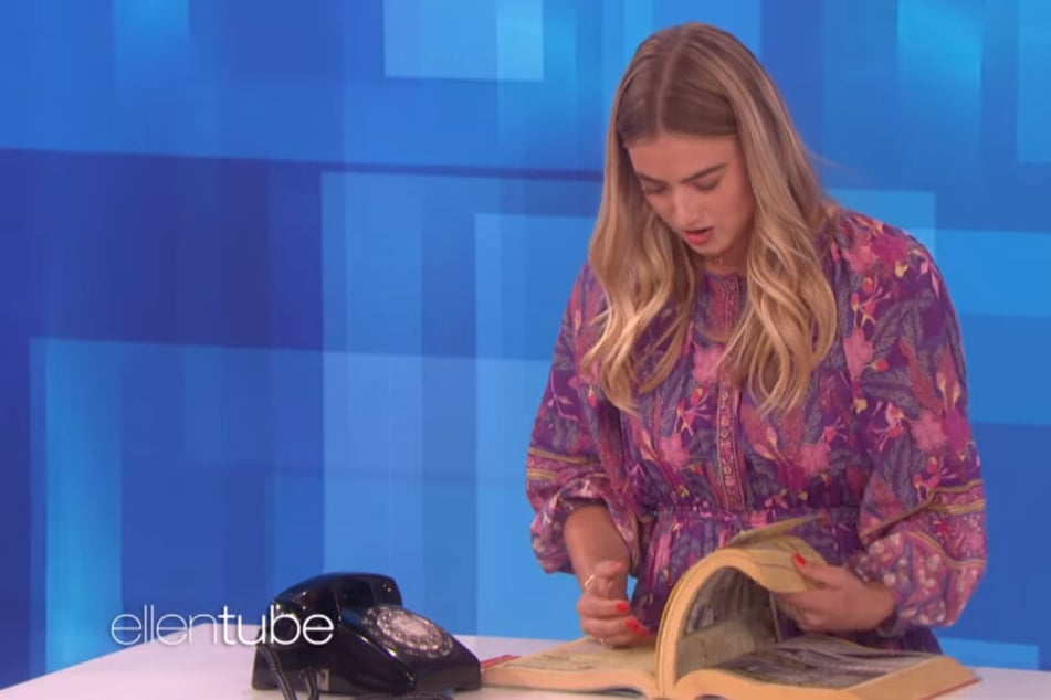 Verzweifelt versucht die Teenagerin eine Nummer im Telefonbuch zu finden.