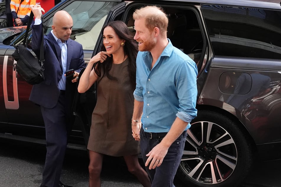 Prince Harry (r.) and his wife Meghan Markle (c.) arrive for a visit to Batyr, a mental health engagement programme, at Swinburne University of Technology in Melbourne on Thursday.