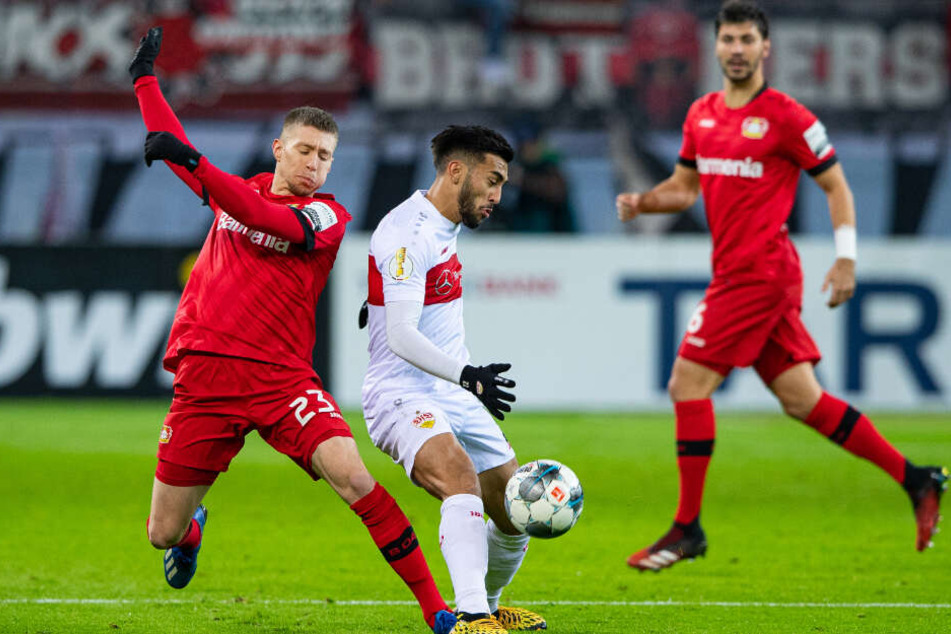 Leverkusens Mitchell Weiser (l) und Stuttgarts Nicolas Gonzalez (M) kämpfen um den Ball.