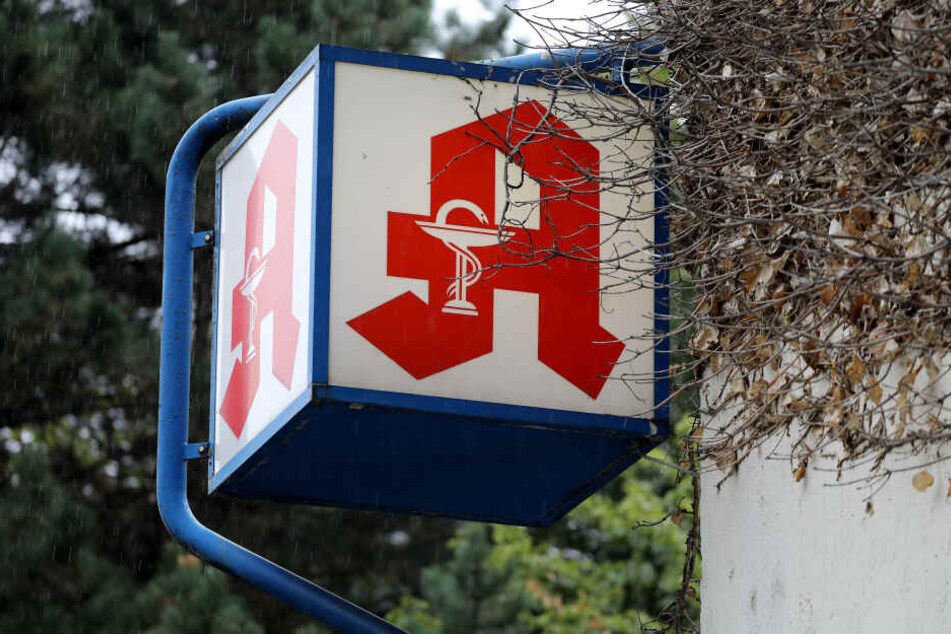 Ein Apotheken Logo hängt vor einer Apotheke.
