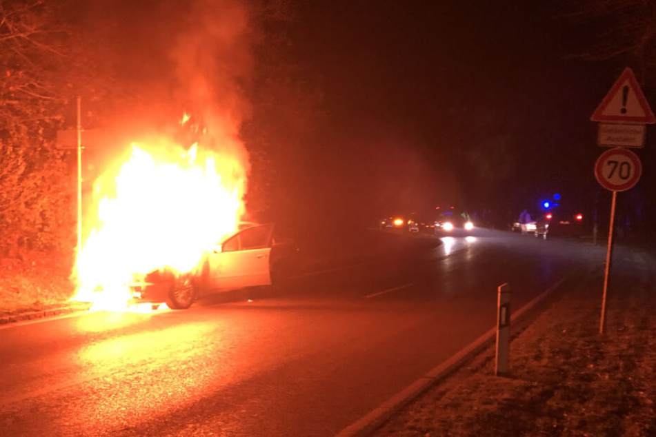 Auf einer Landstraße steht das brennende Fahrzeug.