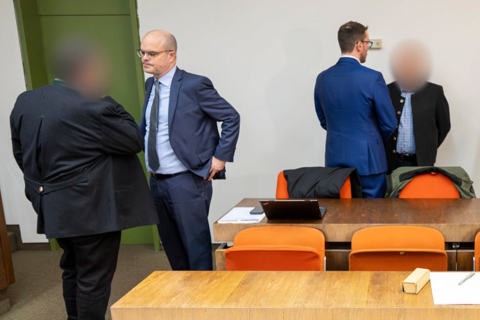 Die zwei beschuldigten Bahnmitarbeiter stehen vor Prozessbeginn um das tödliche Zugunglück bei ihren Anwälten.