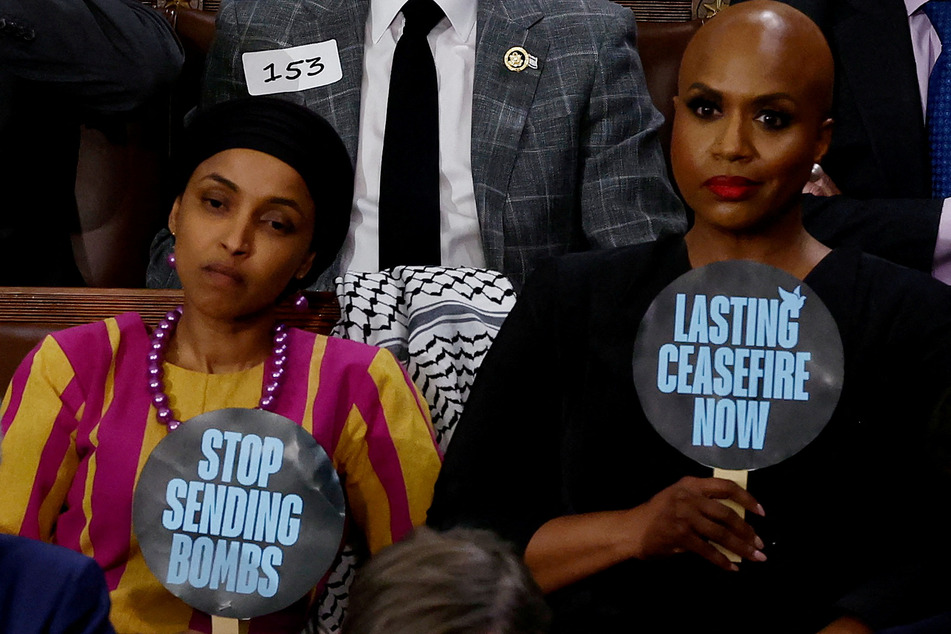 Congresswomen Ilhan Omar (l.) and Ayanna Pressley hold signs reading "Stop Sending Bombs" and "Lasting Ceasefire Now" during Biden's State of the Union address, to protest the administration's support for Israel's assault on Gaza.