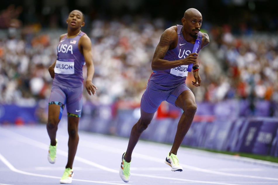 Quincy Wilson of Team USA passes the baton to Vernon Norwood in action during the men's 4x400 relay round 1 at the Paris Olympics.