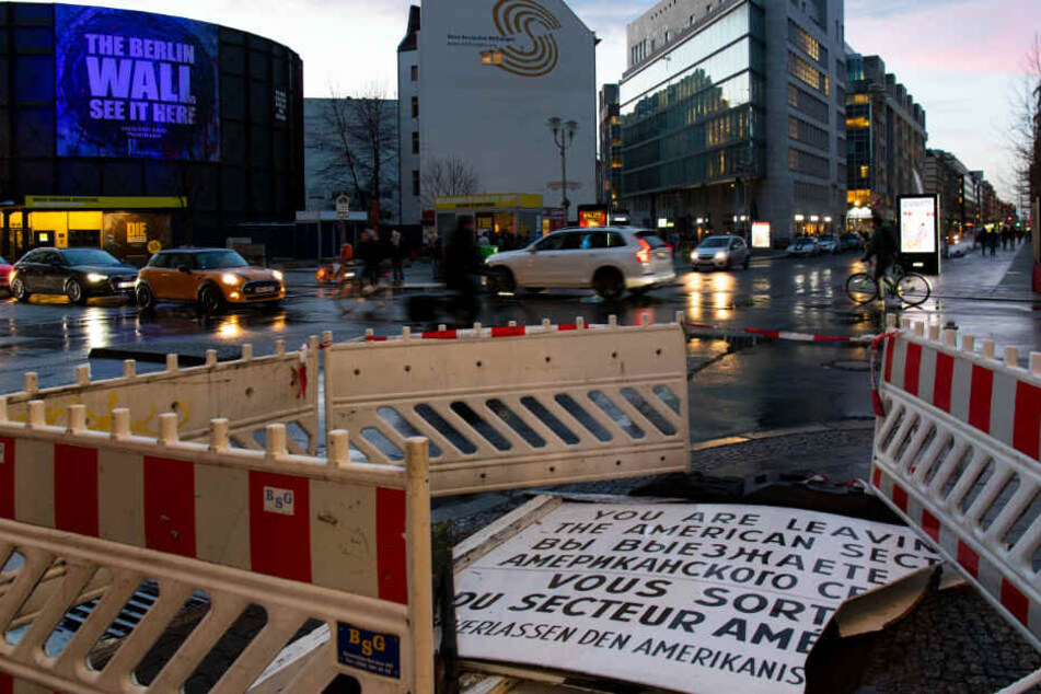 Die beschädigte Replik des berühmten Schildes am Checkpoint Charlie liegt nach dem Sturm auf der Straße.