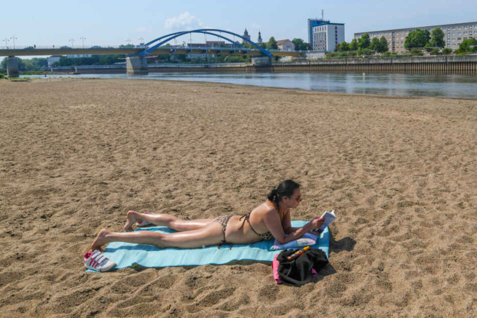 Eine Frau sonnt sich auf einer großen Sandbank am polnischen Ufer des Niedrigwasser führenden Grenzflusses Oder.