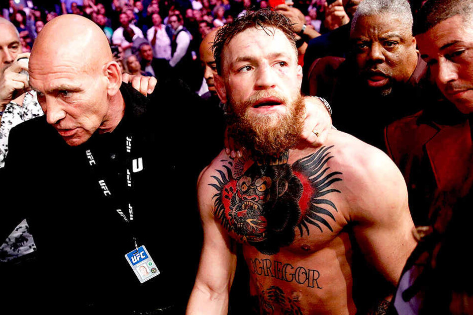 Conor McGregor muss nach dem Auseiandersetzungen aus der Halle geführt werden.