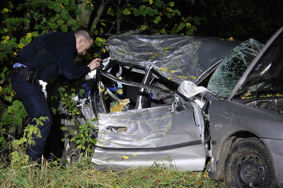 Ein Polizist fotografiert nach dem schrecklichen Unfall das Fahrzeugwrack.