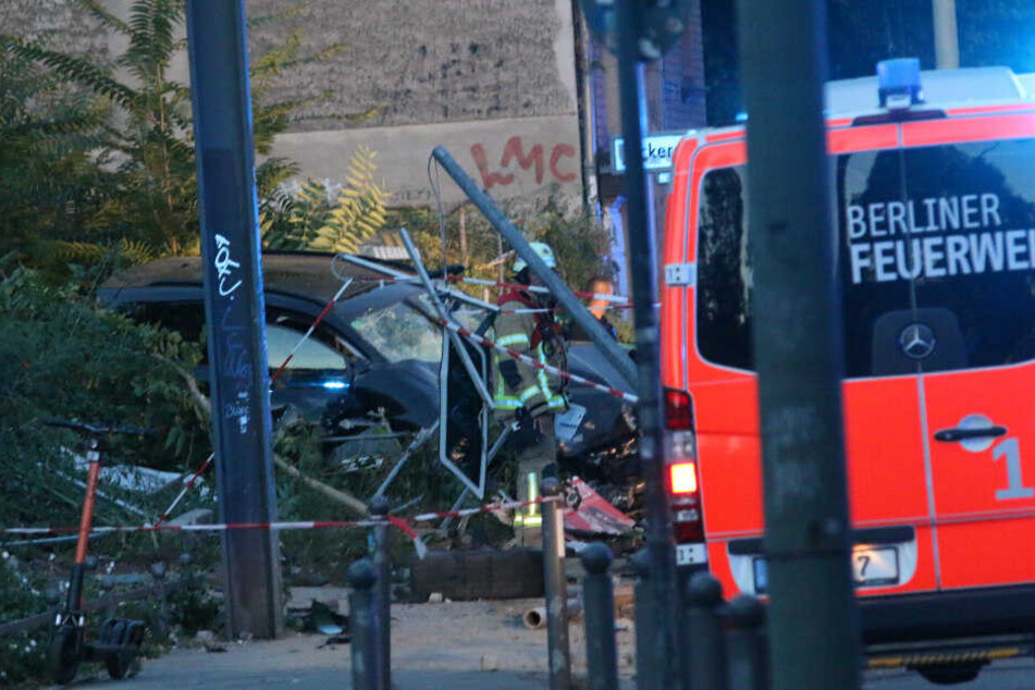 Ein Feuerwehrmann steht bei dem Unfallwagen.