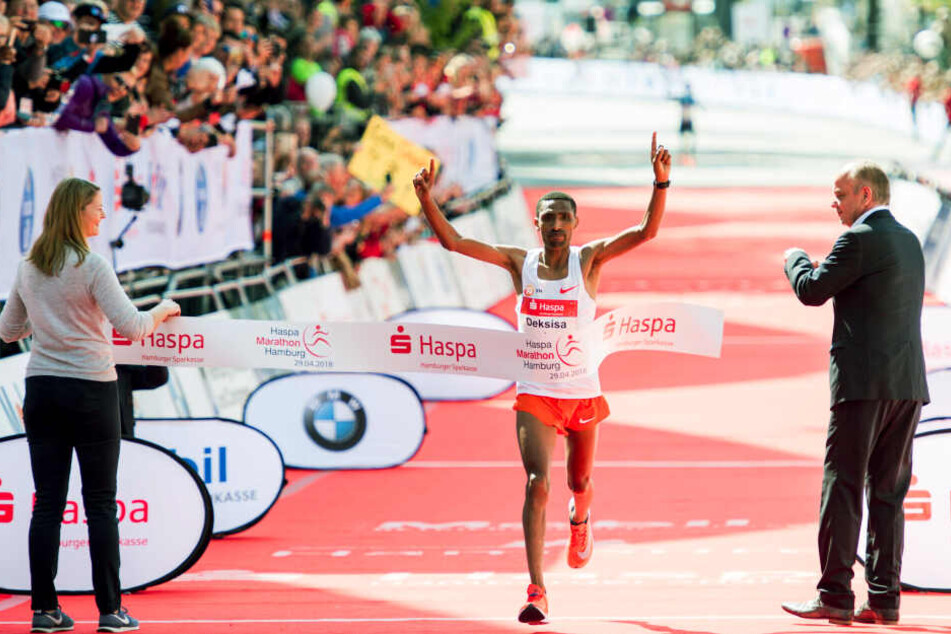 Solomon Deksisa aus Äthiopien jubelt beim Zieleinlauf des 33. Hamburg Marathon vor den Messehallen.