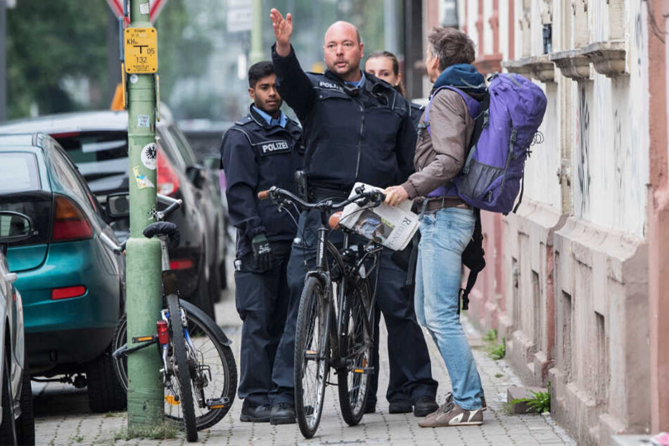 Zwei Polizisten und zwei Anwohner unterhalten sich im Sperrgebiet Frankfurt-Westend.