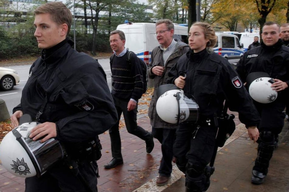 Von Polizisten geschützt verlässt Bernd Lucke den Campus.