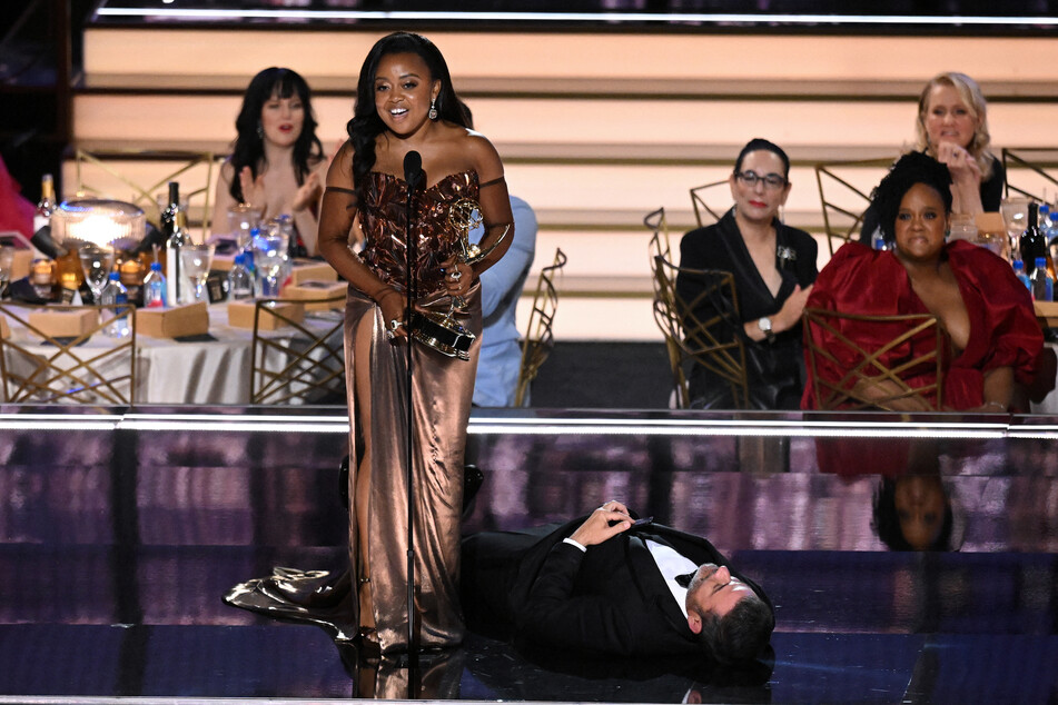Jimmy Kimmel lays on the ground continuing his comedy bit with Will Arnett during Quinta Brunson's acceptance speech.