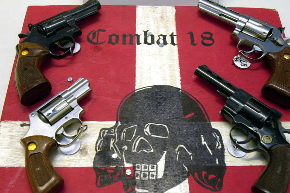 Das Archivbild zeigt Waffen und ein Schild der nun verbotenen Neonazi-Gruppe "Combat 18".