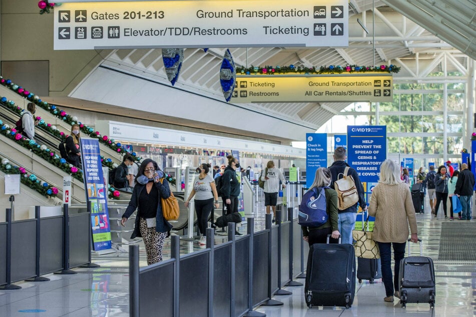 Travelers make their way through the Ontario International Airport in California as the number of Covid-19 cases are on the rise.