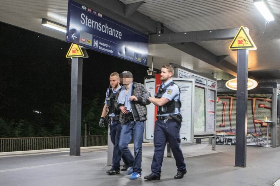 Zwei Beamte führen den betrunkenen Mann ab.
