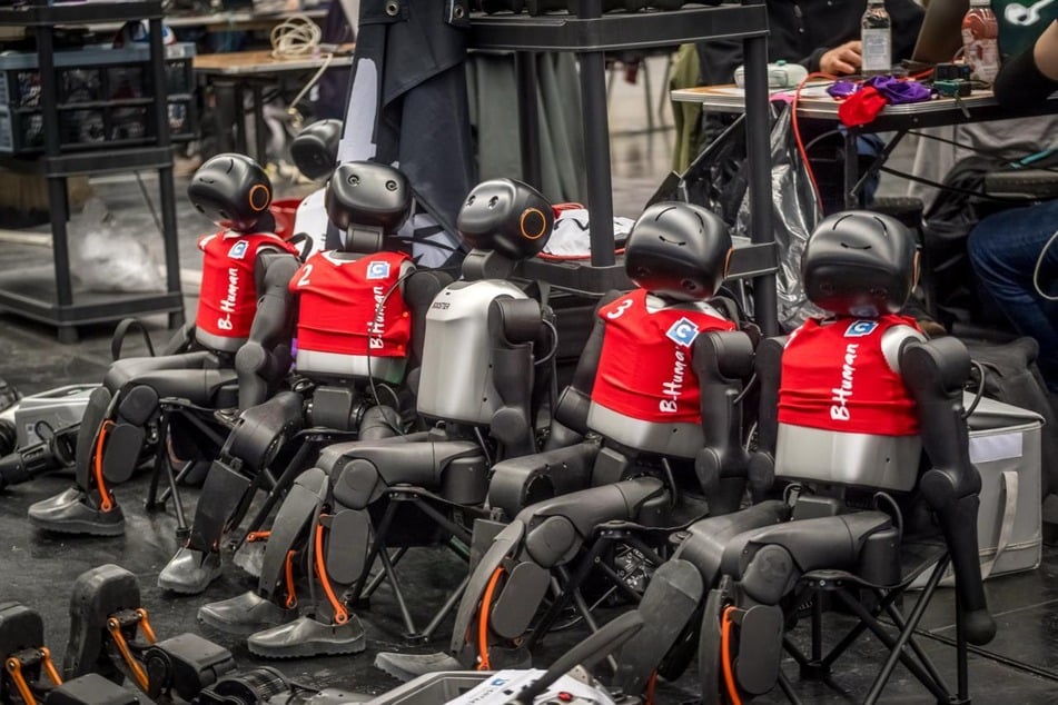 In Klappstühlen warten die Roboter auf ihren Einsatz.