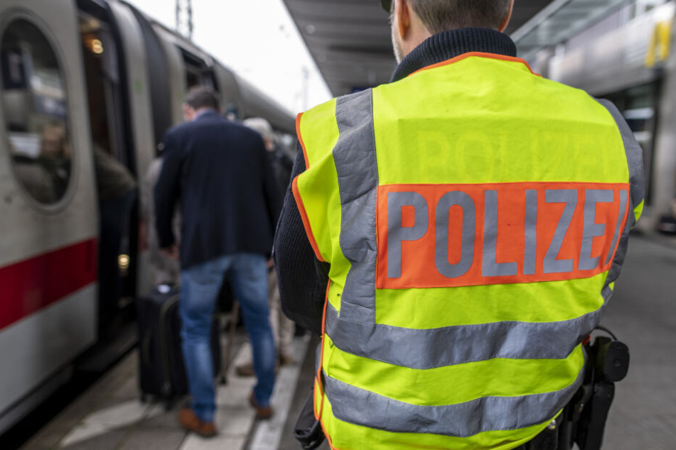 Ein Beamter der Bundespolizei beobachtet den Einstieg von Passagieren in einen Zug.