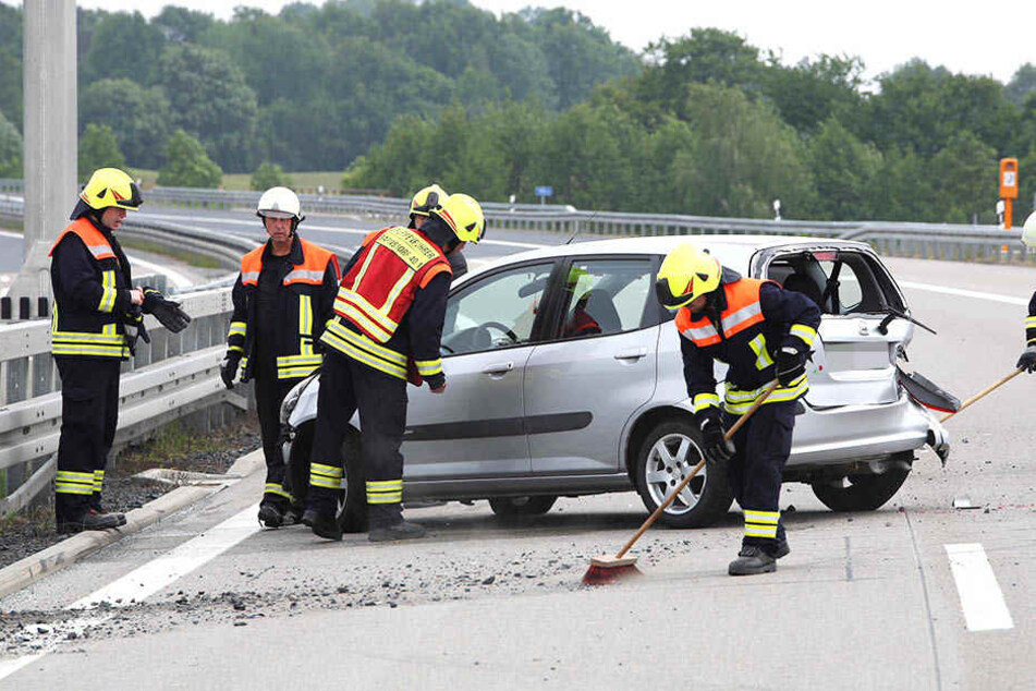Helfen reinigen nach einer Kollision auf der BAB 13 die Fahrbahn.