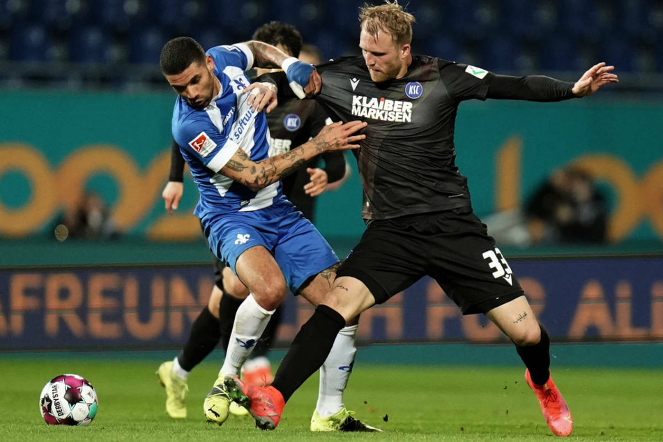Darmstadts Victor Palsson (l.) und Karlsruhes Stürmer Philipp Hofmann kämpfen um den Ball: In der ersten Halbzeit waren Chancen Mangelware.