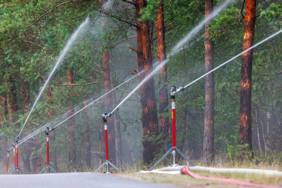 Die Feuerwehr hat Kreisregner zur Eindämmung der Flammen aufgestellt.